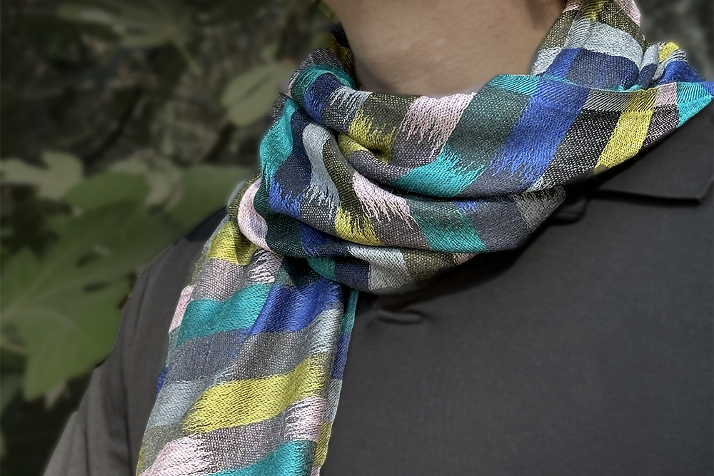 Person wearing a colorful striped scarf with a blurred natural background